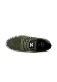 Olive green suede skate shoes with matching laces, white rubber sole, and black logo on side. Flat design with a rounded toe.