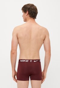 Maroons Nike boxerbokser med en hvid mærkevare elastik. Fremstillet af et glat, strækbart materiale, med et tætsiddende design og en kort benlængde.