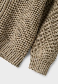 Strickpullover mit einem strukturierten, beigen Muster, das Flecken in Blau und Orange aufweist. Ribbenbündchen und Saum sorgen für eine enganliegende Passform.