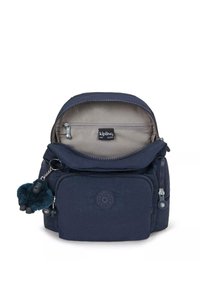 Námořnicky modrý batoh vyrobený z odolné tkaniny, s několika zipovými oddíly, vnitřní kapsou a připojeným huňatým klíčenkou ve tvaru gorily.