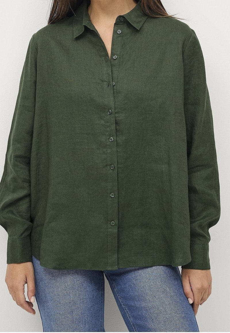 Camicia button-up in lino verde scuro con colletto, maniche lunghe e una vestibilità rilassata. Presenta bottoni sul davanti e un tessuto texturizzato.