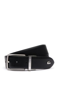 Cinturón de cuero perforado negro con hebilla de metal plateado y logo de Lacoste. Presenta una textura suave y un diseño de punta redondeada.