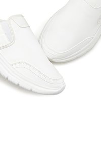 White slip-on sneakers featuring a smooth leather upper, elastic side panels, and a textured rubber sole. Clean design with minimal accents.