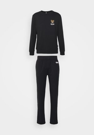 Sweatshirt noir et pantalon assorti en tissu doux. Le sweatshirt arbore un graphisme d'ours et le logo de la marque ; pantalon avec une taille élastique.