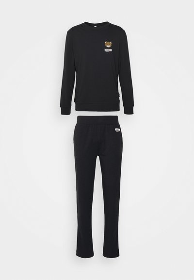 Black sweatshirt and matching pants made of soft fabric. Sweatshirt features a bear graphic and brand logo; elastic waistband on pants.