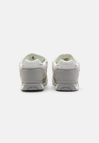 Hvide og grå lædersneakers med en glat finish, der har en polstret krave og en tekstureret sål. Branding på bagenden.