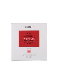 Korres blush compact in white textured packaging, featuring a vibrant red label with gold accents. Text indicates "Wild Rose" and weight.