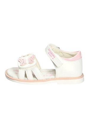 Biała i różowa sandałka dla małego dziecka z motylkową dekoracją i rzepem na kostce, płaska podeszwa i otwarty przód.