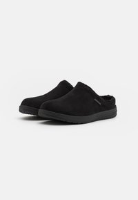 Zwarte instap schoenen van suede, met een zachte binnenvoering en een gestructureerde rubberen zool voor grip. Eenvoudig, naadloos ontwerp.