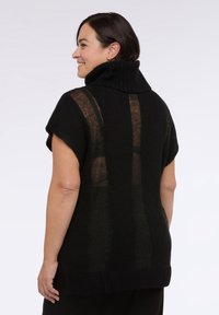 Suéter negro de punto con un cuello alto de canalé, mangas cortas amplias y una textura a rayas con diferentes niveles de transparencia. Presenta un ajuste relajado.