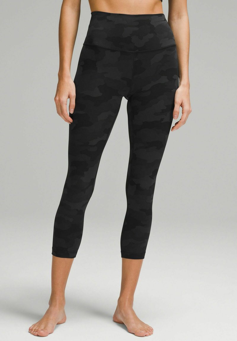 Black camo leggings with a high waist, featuring a smooth, stretchy fabric and a cropped length, providing a fitted silhouette.