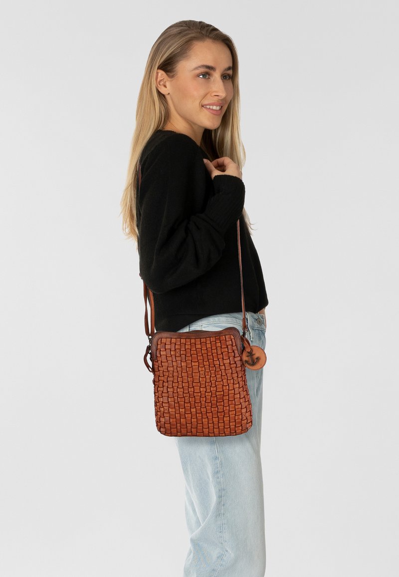 Borsa a tracolla in pelle intrecciata marrone con forma rettangolare, tracolla regolabile e pendente decorativo. Texture liscia e design strutturato.