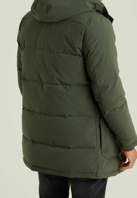 Giacca a piumino verde oliva con design trapuntato orizzontale, cappuccio e tasche laterali; caratterizzata da un materiale esterno liscio e traspirante.