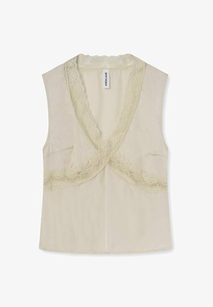 Blusa senza maniche color crema con scollo a V profondo rifinito con pizzo smerlato e una leggera sovrapposizione sul davanti.