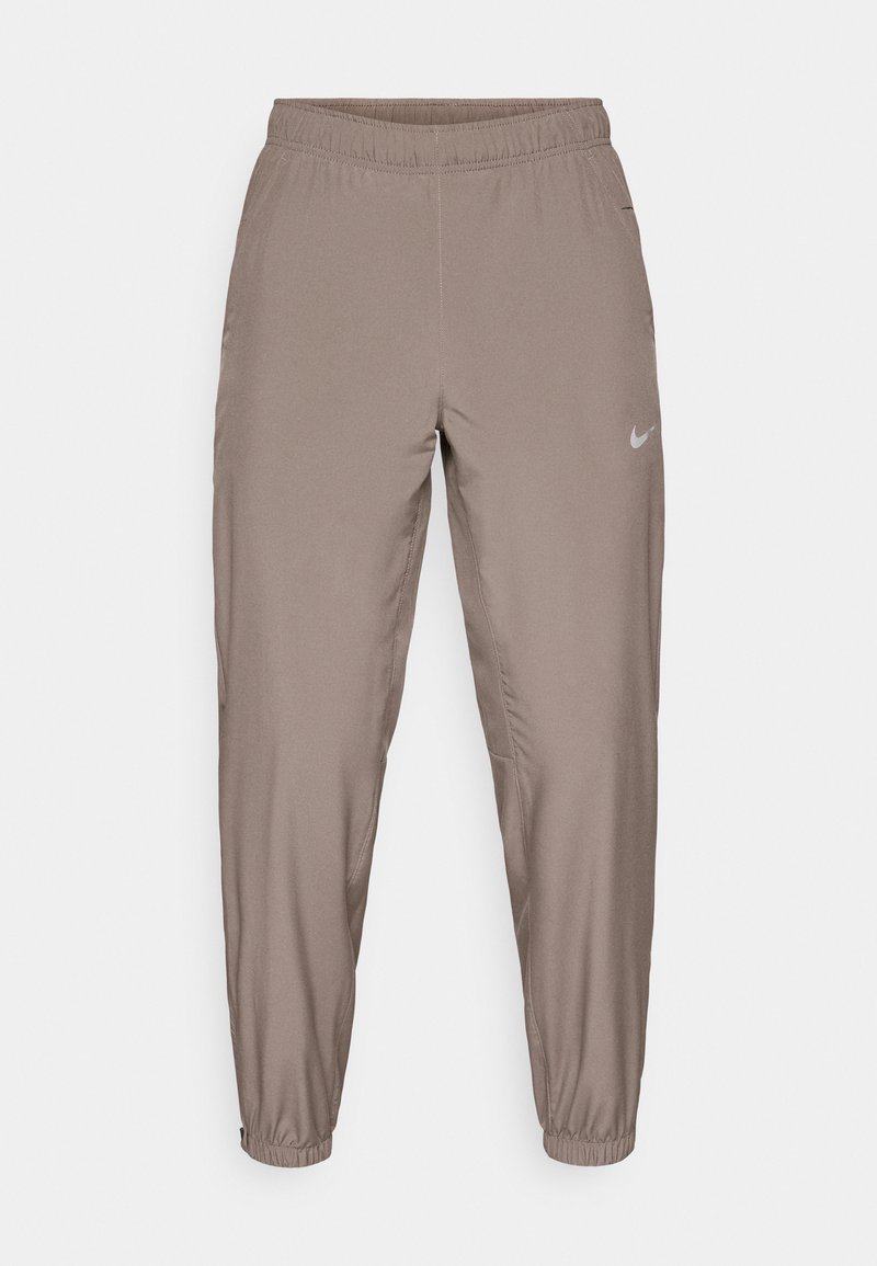 Nike träningsbyxor i en ljusbrun färg, med elastisk midja, avsmalnande ben och sidofickor. Slät, lättvikts tyg.