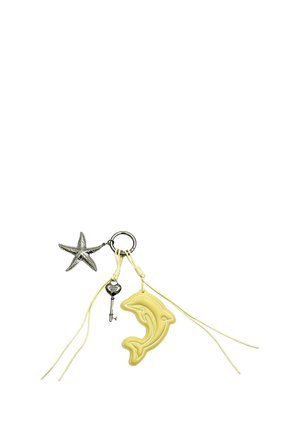Sleutelhanger met drie bedels: een zilveren zeester, een kleine zilveren sleutel en een gele hanger in de vorm van een dolfijn met aangehechte koordjes.