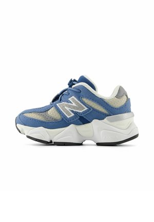 Sneaker New Balance blu e grigio con suola spessa bianca, pannelli in rete e grande logo "N" di lato, mostrato dall'esterno.