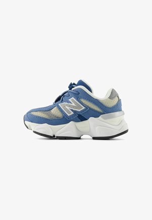 Baskets New Balance bleu et gris avec une épaisse semelle blanche, des panneaux en mesh et un grand logo "N" sur le côté, montrées de l'extérieur.