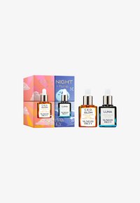 Deux huiles de soin Sunday Riley avec compte-gouttes : C.E.O. Glow Vitamin C + Curcuma et Luna Sleeping Night Oil, accompagnées d'un emballage assorti pour le jour et la nuit.