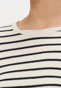 Gestreiftes Kurzarmoberteil in Off-White und Schwarz, mit gerippter Textur und Rundhalsausschnitt. Die Streifen sind gleichmäßig verteilt.