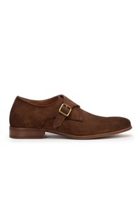 Zapato de ante marrón con punta redondeada, correa simple y detalle de hebilla de latón. Tacón de madera plana, textura suave y diseño minimalista elegante.