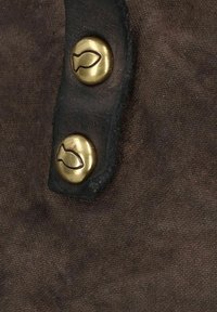 Tela marrón con una superficie texturizada que presenta dos botones de latón, cada uno grabado con un diseño de pez, sujetos por pestañas de cuero negro.