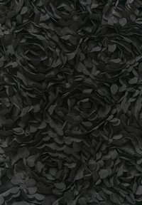 Tessuto nero ricoperto di applicazioni floreali tridimensionali, con forme di petali sovrapposti e una consistenza morbida, creando un motivo floreale.