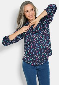 Marineblouse met een kleurrijke, abstracte print in tinten van roze, blauw en groen. Losse pasvorm, elastische manchetten en een afgeronde zoom.