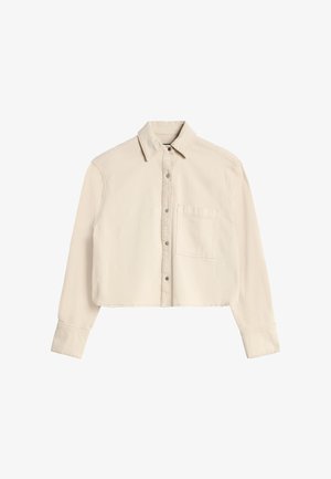 Licht beige cropped overhemd met lange mouwen, puntkraag, metalen drukknoopsluiting en een borstzak aan de linkerkant.
