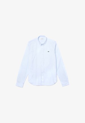 Lichtblauw button-up shirt van katoen, met een klassieke kraag, lange mouwen en een klein groen Lacoste-logo op de borst.