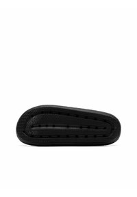 Suola di sneaker nera che mostra una superficie in gomma texturizzata con scanalature e fori di ventilazione, forma piatta e bordo anteriore arrotondato.