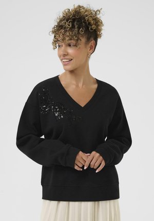 Black V-neck sweatshirt with long sleeves, featuring sequin detailing on one side. Soft material, relaxed fit, ribbed cuffs and hem.