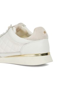 White leather sneaker with quilted pattern, suede heel tab, gold accents, and a textured sole. Features a smooth finish and neutral color scheme.