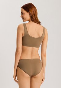 Sujetador marrón sin costuras y bragas de bikini a juego, hechas de un tejido suave y elástico. El sujetador cuenta con tirantes anchos y un diseño de espalda en forma de scoop.