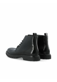 Botines de cuero negro con acabado brillante, cordones en la parte delantera y tiradores, que cuentan con una suela robusta y suturas sutiles.