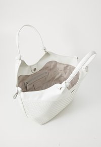 Hvit lær totebag med vevede teksturdetaljer, romslig innside og en glidelåslomme. Har doble håndtak og trykknapp-lukking.
