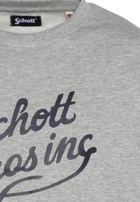 Felpa grigia in cotone misto, presenta un collo rotondo e un grande testo nero che recita "Schott". Morbida al tatto con polsini a costine.