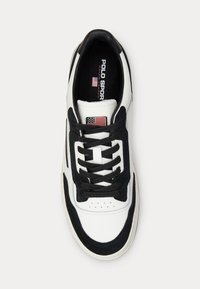 Valkoiset ja mustat tennarit, joissa on nahkainen päällinen, mustat mokkanahkaosat, litteät nauhat, rei'itetty varvas ja logopatch, jossa on Amerikan lippu.