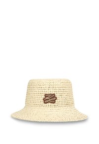 Crème kleurige geweven strooien emmerhoed met een gestructureerd oppervlak en een bruine logopatch aan de voorkant. Brede, relaxte rand.