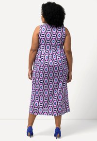 Maxikleid mit einem lebhaften geometrischen Muster in Pink, Lila und Schwarz, ärmelloses Design, tailliert und mit fließendem Rock.