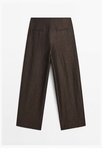 Pantalon large marron foncé avec deux poches passepoilées à l’arrière sur fond blanc.