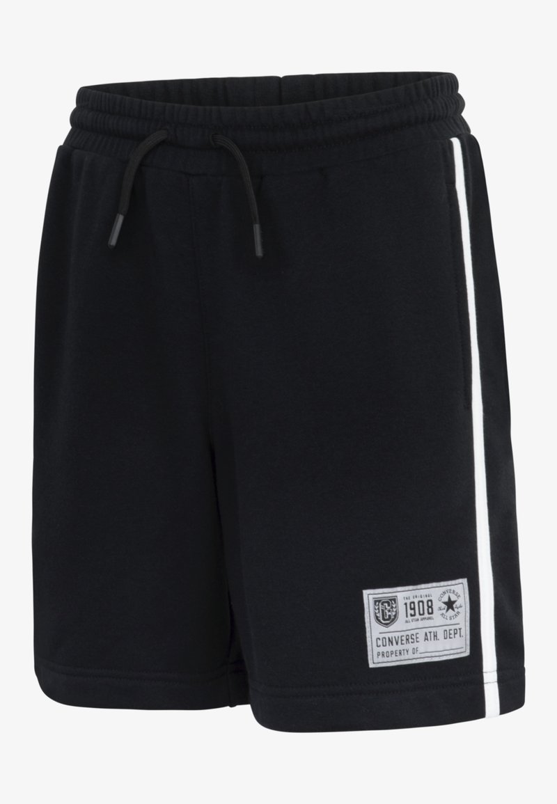 Black cotton shorts featuring an elastic waistband, white side stripes, and a branded patch on the front. Smooth texture, casual design.