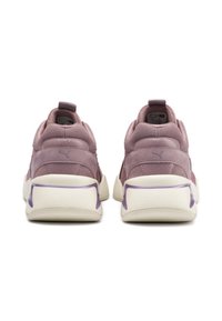 Lila mockaskor med en böjd vit sula och ljusare lila detaljer. Har en vadderad ankelkrage och logotypdetalj på hälen.