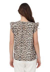 Blusa con stampa animalier leopardata, con maniche a svolazzo, apertura posteriore a goccia e tessuto leggero e trasparente dai toni crema e marrone.