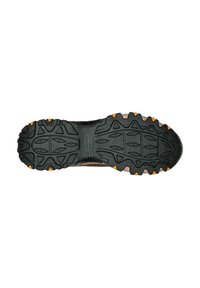 Black rubber shoe sole with deep treads and orange accents. Features a textured surface and angular patterns for enhanced grip.