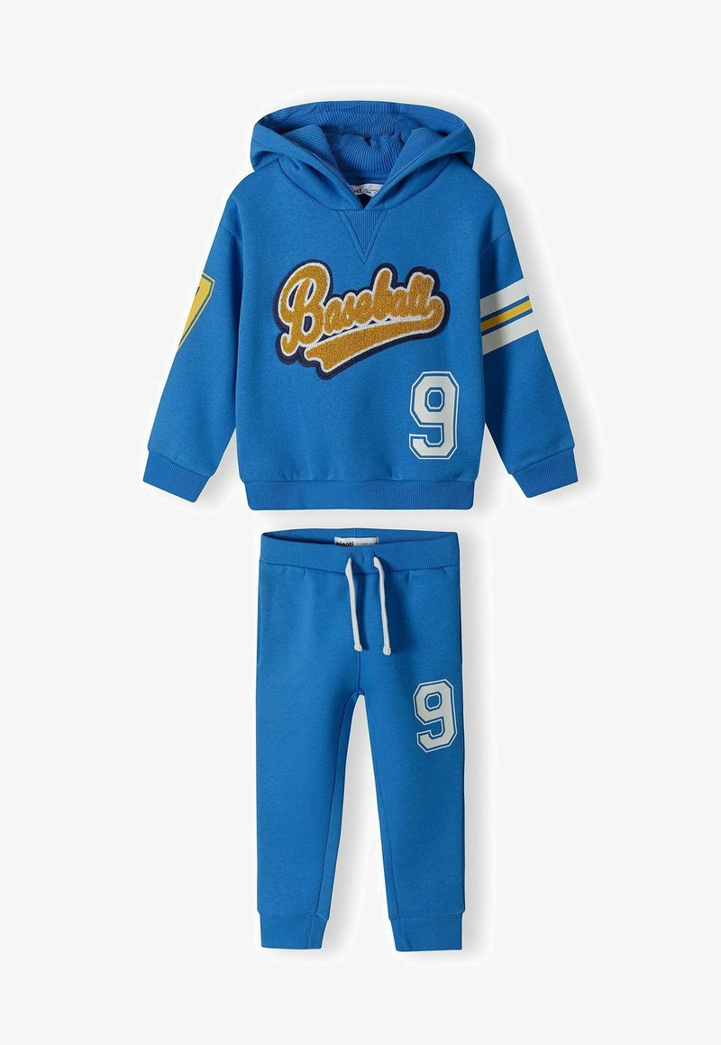 Blå hoodie med texten "Baseball", nummer 9 och randiga detaljer. Matchande blå byxor med nummer 9. Båda i mjukt material.