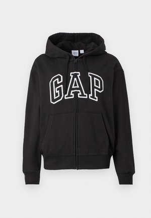 Černá mikina na zip s předními kapsami a velkým logem "GAP" v bílé obrysové barvě přes hruď.