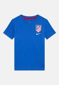 T-shirt in cotone blu con collo rotondo, caratterizzata da un logo e un distintivo stampati in rosso, bianco e blu sul petto. Maniche corte.