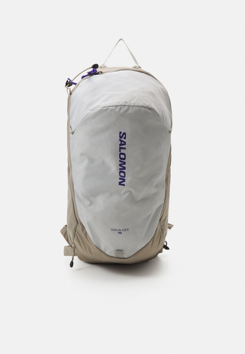Salomon Trailblazer 10 hátizsák, szürke és barna dizájnnal, sima textúrával, felső fogantyúval és lila márkázással az elején.
