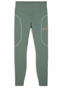 Leggings sportivi verdi realizzati in materiale elasticizzato, con cuciture bianche e un logo Puma dorato sul lato sinistro.